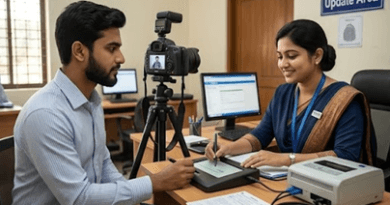 Man Undergoing Biometric Update a Camera on a Tripod Records As a Female Official Stamps a Document at a Desk Labeled Biometric Update Area