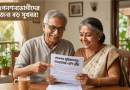 Two Smiling Elderly Indian Couple Sit at a Table Reading a Pension Information Document Together at Home with a Glass of Tea on the Table