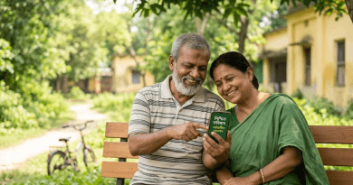 Elderly Indian Couple Sits on a Park Bench Smiling While Reading a Small Green Book Together